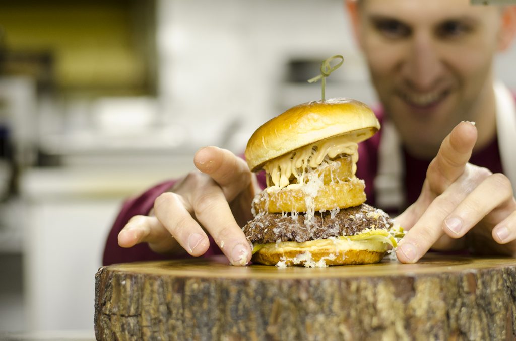Chef Johnny Oran puts the finishing touches on the Firehouse Burger
