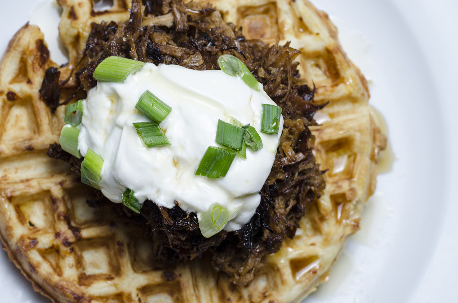 Pulled pork over a savoury cheese waffle.